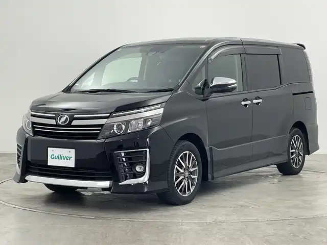 トヨタ ヴォクシー ZS 煌Ⅱ 群馬県 2016(平28)年 7.4万km ブラック 社外１０インチナビ/CD/DVD/Bluetooth/フルセグTV/社外１０．１インチフリップダウンモニター/バックカメラ/衝突軽減ブレーキ/車線逸脱警報/オートマチックハイビーム/LEDヘッドライト/前後ドライブレコーダー/ETC/クルーズコントロール/両側パワースライドドア/純正AW/純正フロアマット/ウォークスルー/３列シート/スマートキー/プッシュスタート