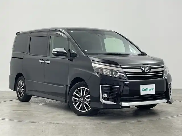 トヨタ ヴォクシー ZS 煌Ⅱ 群馬県 2016(平28)年 7.4万km ブラック 社外１０インチナビ/CD/DVD/Bluetooth/フルセグTV/社外１０．１インチフリップダウンモニター/バックカメラ/衝突軽減ブレーキ/車線逸脱警報/オートマチックハイビーム/LEDヘッドライト/前後ドライブレコーダー/ETC/クルーズコントロール/両側パワースライドドア/純正AW/純正フロアマット/ウォークスルー/３列シート/スマートキー/プッシュスタート