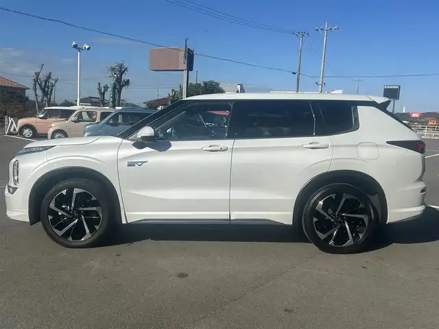 三菱 アウトランダー ＰＨＥＶ P 愛媛県 2024(令6)年 0.4万km ホワイトダイヤモンド 純正ナビ（Bluetooth/AppleCarPlaｙ）/アラウンドビューモニター/ヘッドアップディスプレイ/BOSE製スピーカー/マイパイロット/マッサージ機能（D/N席）/置くだけ充電/全席シートヒーター（サードシート除く)/ステアリングヒーター/シートメモリー/パドルシフト/サンルーフ/パワーシート/純正20インチアルミホイール/純正フロアマット/前後コーナーセンサー/ダウンヒルアシストコントロール/LEDヘッドライト/スマートキー×２