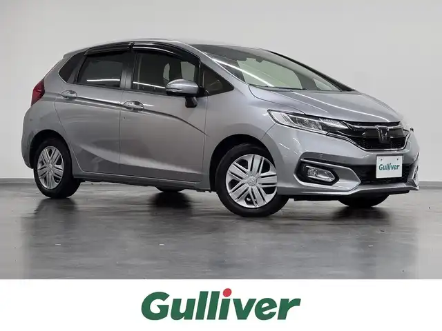ホンダ フィット 13G L ホンダセンシング 三重県 2019(令1)年 3万km ルナシルバーM ガソリン/FF/フロアCVT/JVCケンウッド 8インチ『彩速ナビ』 MDV-S811HDL/（FM/AM/CD/DVD/iPod/USB/SD/内蔵メモリ/TV/Bluetooth/HDMI）/バックカメラ/ドライブレコーダー 全方位＋後方/ビルトイン ETC/Honda SENSING/・衝突軽減ブレーキ［CMBS］/・車線維持支援システム［LKAS］/・アダプティブクルーズコントロール［ACC］/・路外逸脱抑制機能/・標識認識機能/・先行車発進お知らせ機能/・VSA（ABS＋TRC、横すべり抑制）/・コーナーセンサー（純正・ディーラーOP）/など/装備/・オートエアコン/・オートライト/・LEDヘッドランプ/・ステアリングスイッチ/・インフォメーションディスプレイ/・ECONスイッチ/・電動格納ドアミラー/・プッシュスタート/・スマートキーx2/・純正ホイールキャップ＋15インチスチールホイール/など
