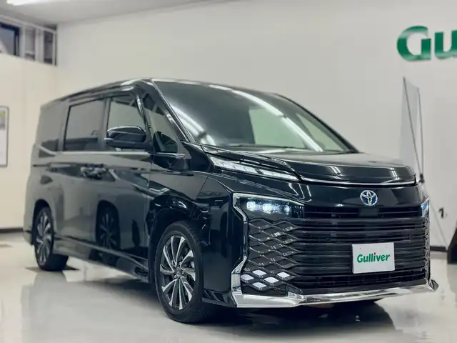 トヨタ ヴォクシー ハイブリッド S－Z 滋賀県 2023(令5)年 3.5万km グリッターブラックガラスフレーク ワンオーナー/純正10.5インチディスプレイオーディオplus/　コネクティッドナビ/フルセグ/Bluetooth//appleCarPlay/Androidauto/CD DVDデッキ/バックカメラ/14型有機EL後席ディスプレイ/ETC2.0ユニット/快適利便パッケージHi/ハンズフリーデュアルパワースライドドア/パワーバックドア/ナノイーX/ステアリングヒーター/Toyota Safety Sense /プリクラッシュセーフティ/レーントレーシングアシスト/レーンディパーチャーアラート/レーダークルーズコントロール/オートマチックハイビーム/ロードサインアシスト/ドライバー異常時対応システム/プロアクティブドライビングアシスト/発進遅れ告知機能/パーキングブレーキサポート/プロジェクター式LEDヘッドランプ/純正フロアマット/純正ドアバイザー/スマートキー×2/プッシュスタート/カロッツェリア ウーハー/