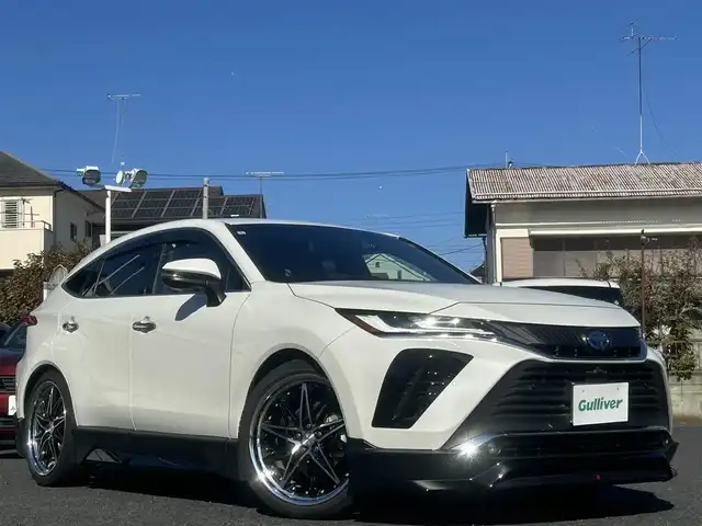 トヨタ ハリアー ハイブリッド Z 宮城県 2022(令4)年 3.6万km ホワイトパールクリスタルシャイン 4WD/ワンオーナー/純正ナビ/・Bluetooth/TV/USB/、AppleCarPlay/Android Auto/Toyota Safety Sense/・プリクラッシュセーフティ/・レーントレーシングアシスト/・レーダークルーズコントロール/・アダプティブハイビームシステム/・ロードサインアシスト/先行車発進告知機能/インテリジェントクリアランスソナー/リヤクロストラフィックオートブレーキ＋ブラインドスポットモニター　　　　　　　　　　　　　　　　　　　　　　　　 /車両接近通報装置/横滑り防止装置/盗難防止装置/衝突被害軽減システム/JBLプレミアムサウンドシステム/オートライト/電動格納ミラー/ドアバイザー/純正アルミホイールあり（スタッドレス装着）/WORK製21インチアルミホイール（SCHWERT SG1）/GRフロントスポイラー/GRサイドスカート/GRリヤバンパースポイラー＆GRスポーツマフラー/GRフロントバンパーガーニッシュ/ローダウン（純正スプリングあり）/ETC/取扱説明書/保証書/スペアキー1本