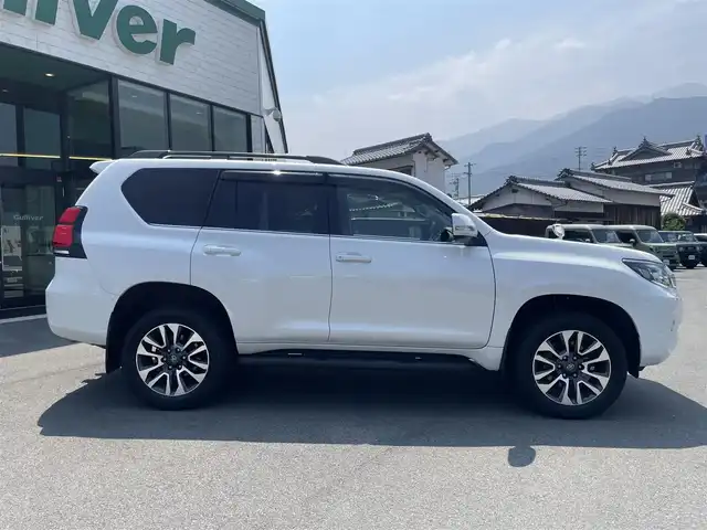 トヨタ ランドクルーザー プラド TX Lパッケージ 愛媛県 2023(令5)年 1.2万km ホワイトパールクリスタルシャイン サンルーフ/ヒッチメンバー/プリクラッシュセーフティ/レーダークルーズコントロール/レーンディパーチャーアラート/クリアランスソナー /ロードサインアシスト/先行車発進お知らせ/社外8インチSDナビ【AVIC-RL812】/　CD/DVD/Bluetooth/MSV/フルセグTV/バックカメラ/ビルトインETC/ブラックレザーシート/前席パワーシート/前席シートヒーター/ベンチレーション/ブラックルーフレール/純正19インチ AW/オートライト/LEDヘッドライト/フロントフォグ/プッシュスタート/フロアマット