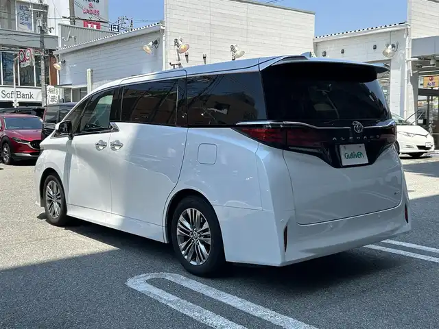 トヨタ アルファードハイブリット Z 大阪府 2024(令6)年 1万km プラチナホワイトパールマイカ ワンオーナー/左右独立ムーンルーフ（電動シェード＆巻き込み防止機能付）/後席用パワーサイドサンシェード/デジタルインナーミラー/純正14インチHDDナビ/フリップダウンモニター（V12T-R72C）/パノラミックビューモニター/ETC2.0/ToyotaSafetySense/・プリクラッシュセーフティー/・レーントレーシングアシスト【LTA】/・レーンディパーチャーアラート【LDA】/・レーダークルーズコントロール/・アダプティブハイビームシステム【AHS】/・ロードサイドアシスト【RSA】/・ドライバー異常時対応システム/・プロアクティブドライビングアシスト【PDA】/・発進遅れ告知機能【TMN】/ブラインドスポットモニター【BSM】/安心降車アシスト【SEA】/後方車両接近告知/周辺車両接近時サポート/セカンダリーコリジョンブレーキ/リアクロストラフィックアラート/パーキングサポートブレーキ/リアカメラディクション/クリアランスソナー/保証書・記録簿（R6.9/R7.10）