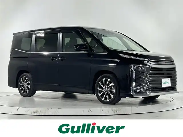 トヨタ ヴォクシー ハイブリッド S－Z 佐賀県 2022(令4)年 6.9万km アティチュードブラックマイカ 純正10.5インチディスプレイオーディオ/コネクティッドナビ対応/ディーラーオプションDVDキット/フルセグＴＶ/Bluetooth/CD/DVD/carplay/純正14インチフリップダウンモニター/シグネチャーイルミグリル/バックカメラ/衝突被害軽減システム/レーダークルーズコントロール/レーンアシスト/ブラインドスポットモニター/パーキングサポートブレーキ/ダウンヒルアシストコントロール/ロードサインアシスト/オートライト/オートマチックハイビーム/LEDヘッドライト/ＬＥＤフォグライト/クリアランスソアー/電動パーキング/ブレーキホールド/両側パワースライドドア/運転席・助手席シートヒーター/後席サンシェード/ハーフレザーシート/純正フロアマット/純正17インチアルミホイール/スマートキー/スペアキー×１