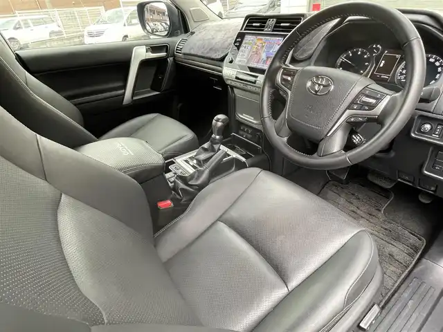 トヨタ ランドクルーザー プラド TX Lパッケージ マットブラED 福岡県 2023(令5)年 3.3万km ブラック ワンオーナー/7人乗り/4WD/純正9インチコネクテッドナビ/　(AM/FM/Bluetooth/Miracast/フルセグTV)/パノラミックビューモニター/バック/サイド/フロントモニター/トヨタセーフティーセンス/・プリクラッシュセーフティ/・レーンディパーチャーアラート/・ロードサインアシスト/・レーダークルーズコントロール/・先行車発進告知/ブラインドスポットモニター/クリアランスソナー/オートマチックハイビーム/横滑り防止/センターデフロック/ダウンヒルアシストコントロール/セカンドスタートモード/ヒーターアイドルアップ/排出ガス浄化/ヘッドランプクリーナー/ラウンジ照明調光/RAYS20インチアルミホイール/黒ルーフレール/黒レザーシート/コムテック前方ドライブレコーダー【HDR002】/ビルトインETC2.0/革巻きステアリング/ステアリングスイッチ/パワーシート(D/N)/シートヒーター/ベンチレーター(D/N)/社外インパネカバー/純正センターコンソールカバー/USBポート/アクセサリーソケット/スペアキー×1/ISOFIX/保証書/取扱説明書/ナビ取扱説明書