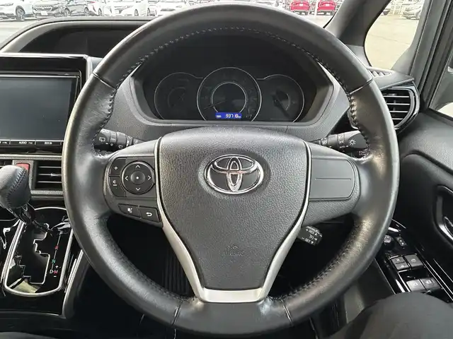 トヨタ ヴォクシー ZS 煌 岡山県 2018(平30)年 9.4万km イナズマスパーキングブラックガラスフレーク 登録時走行距離93718km/純正9インチナビ/フルセグTV(AM.FM.CD.DVD.TV.BT)/両側パワースライドドア/バックカメラ/ビルトインETC/トヨタセーフティセンス/・衝突軽減ブレーキ/・レーンキープアシスト/・オートマチックハイビーム/横滑り防止装置/クルーズコントロール/オートライト/アイドリングストップ/16インチ純正AW/純正フロアマット/プッシュスタート/スマートキー