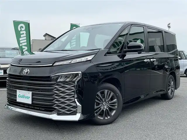 トヨタ ヴォクシー S－G 奈良県 2023(令5)年 2.7万km アティチュードブラックマイカ 片側パワースライドドア/純正ナビ(AM・FM/BT)/バックカメラ/ビルトインETC2.0/Toyota Safety Sense/プリクラッシュセーフティ/クルーズコントロール/レーントレーシングアシスト/レーンディパーチャーアラート/オートブレーキホールド/LEDヘッドライト/純正16インチアルミホイール/社外フロアマット