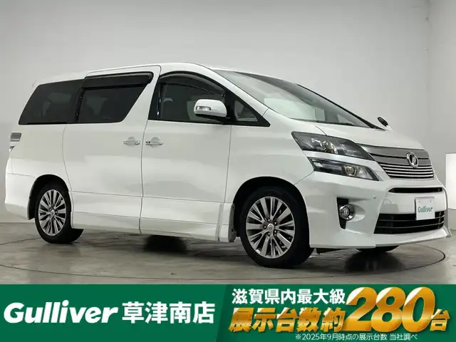 トヨタ ヴェルファイア 2．4Z ゴールデンアイズⅡ 滋賀県 2014(平26)年 8.9万km ホワイトパールクリスタルシャイン 純正ナビ/【CD.DVD.Bluetooth.フルセグTV】/バックカメラ/サンルーフ/フリップダウンモニター/ハーフレザーシート/クリアランスソナー/クルーズコントロール/オートライト/HIDヘッドライト/前後ドライブレコーダー/ETC/両側電動スライドドア/電動リアゲート/AC100V/オットマン/ステアリングスイッチ/スマートキー