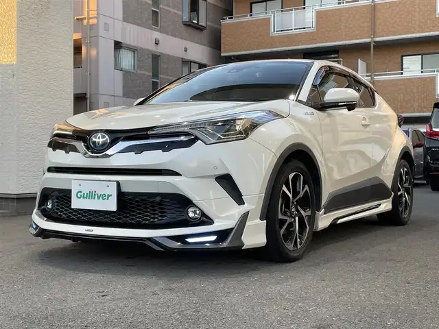 トヨタ Ｃ－ＨＲ G 高知県 2018(平30)年 6.8万km ホワイトパールクリスタルシャイン 登録時走行距離６７１０４ｋｍ/モデリスタエアロ/社外９インチメモリーナビ/　【DVD/Bluetooth/CD/SD/AM/FM】/フルセグTV/バックカメラ/ステアリングスイッチ/ハーフレザーシート/前席シートヒーター/Toyota Sefety Sense/　・プリクラッシュセーフティシステム/　・レーンディパーチャーアラート/　・オートマチックハイビーム/　・レーダークルーズコントロール/LEDヘッドライト/LEDフォグライト/オートライト/プッシュスタート/スマートキー/スペアキー/電動パーキング/ブレーキホールド/前後ドライブレコーダー/ビルトインETC/純正フロアマット/ドアバイザー/整備記録簿/取扱説明書