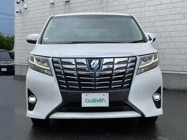 トヨタ アルファードハイブリット G 山形県 2016(平28)年 7.6万km ホワイトパールクリスタルシャイン 禁煙車/4WD/純正10インチナビ//フルセグ/CD/DVD/SD/AM//FM/iPod/BT/AUX/純正フリップダウンモニター/ハーフレザーシート/ETC/クルーズコントロール/プリクラッシュセーフティー/ステアリングスイッチ/オートLEDヘッドライト/オートワイパー/フォグランプ/プッシュスタート