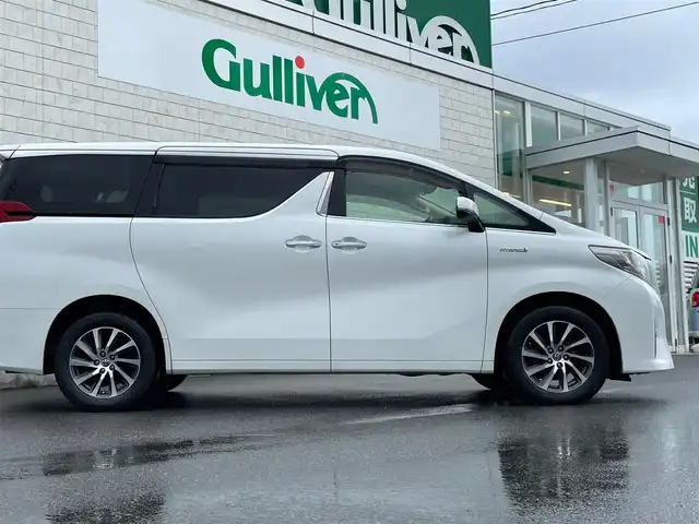 トヨタ アルファードハイブリット G 山形県 2016(平28)年 7.6万km ホワイトパールクリスタルシャイン 禁煙車/4WD/純正10インチナビ//フルセグ/CD/DVD/SD/AM//FM/iPod/BT/AUX/純正フリップダウンモニター/ハーフレザーシート/ETC/クルーズコントロール/プリクラッシュセーフティー/ステアリングスイッチ/オートLEDヘッドライト/オートワイパー/フォグランプ/プッシュスタート