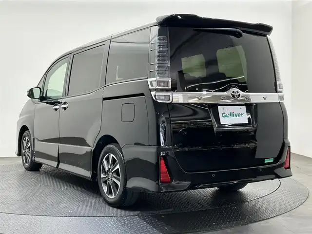 トヨタ ヴォクシー ZS 煌Ⅲ 愛媛県 2021(令3)年 2.6万km ブラック ・１０型ナビ（フルセグＴＶ・ＢＴ・ＣＤ・ＤＶＤ・ＳＤ・ＦＭ・ＡＭ）/・バックカメラ　/・１２．１型後席モニター　/・クルーズコントロール　/・ＥＴＣ　/・衝突軽減ブレーキ　/・オートマチックハイビーム　/・レーンキープアシスト/・両側パワースライドドア/・USB充電