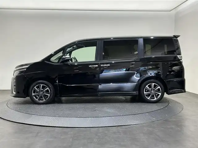 トヨタ ヴォクシー ZS 煌Ⅲ 愛媛県 2021(令3)年 2.6万km ブラック ・１０型ナビ（フルセグＴＶ・ＢＴ・ＣＤ・ＤＶＤ・ＳＤ・ＦＭ・ＡＭ）/・バックカメラ　/・１２．１型後席モニター　/・クルーズコントロール　/・ＥＴＣ　/・衝突軽減ブレーキ　/・オートマチックハイビーム　/・レーンキープアシスト/・両側パワースライドドア/・USB充電