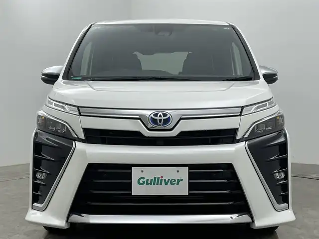 トヨタ ヴォクシー ハイブリッド ZS 煌Ⅲ 岡山県 2021(令3)年 5万km ホワイトパールクリスタルシャイン 純正ナビ/（CD/BT/AUX)/衝突軽減ブレーキ/両側パワースライドドア/ビルトインＥＴＣ/シートヒーター（D/N席）/ハーフレザーシート/ＬＥＤヘッドライト/オートハイビーム/オートライト/LEDフォグランプ/バックカメラ/コーナーセンサー/プッシュスタート/クルーズコントロール/アイドリングストップ/レーンキープアシスト/純正16AW/スマートキー×1/踏み間違い防止/ISOFIX/後席サンシェイド/ステアリングスイッチ/チルトステアリング/充電用USB/シートリフター/シートバックテーブル/ウインカーミラー/ドアバイザー/新車保証書/取扱説明書