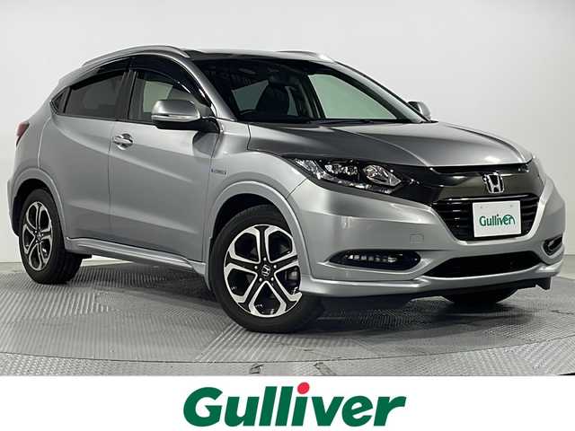 ホンダ ヴェゼル ハイブリッド Z ホンダセンシング 広島県 2017(平29)年 4.1万km ルナシルバーM 禁煙車/純正８型ナビ/バックカメラ/シートヒーター/パワーシート(運転席/助手席)/電動パーキングブレーキ/パドルシフト/レーダークルーズコントロール/ＥＴＣ/ドラレコ/衝突被害軽減システム/レーンキープアシスト/オートライト/フォグランプ/ＬＥＤヘッドライト/チップアップシート/エアバッグ(運転席/助手席/サイド/カーテン)/純正17インチアルミホイール(215/55/R17)