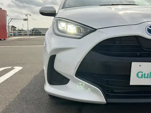 トヨタ ヤリス ハイブリッド Z 佐賀県 2023(令5)年 1万km プラチナホワイトパールマイカ 純正8型ディスプレイオーディオ/・AM/FM/BT/Appple Car Play/Android Auto//・パノラミックビューモニター/・ナビ機能付き/・TVキャンセラー/シートヒーター「運転席/助手席」/ハーフレザーシート/社外センターコンソール/純正前方ドライブレコーダー/純正フロアマット/純正ドアバイザー/新車保証書/取扱説明書/スペアキー1本/Toyota Safety Sense/・プリクラッシュセーフティ/・レーンディパーチャーアラート/・レーントレーシングアシスト（車線中央維持支援）/・アダプティブクルーズコントロール（全車速追従機能付）/・ロードサインアシスト（道路標識認識）/・パーキングサポートブレーキ/・インテリジェントクリアランスソナー/・ブラインドスポットモニター/・リアクロストラフィックオートブレーキ/・ドライバー異常時対応システム/・先行車発進告知機能/・SRSエアバッグ（運転席・助手席＋サイド＋カーテン）/・電子制御ブレーキシステム（ABS・EBD・ブレーキアシスト）/・VSC（車両安定制御システム）/・TRC（トラクションコントロール）/・緊急ブレーキシグナル/・ヒルスタートアシストコントロール