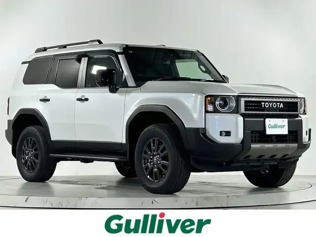 トヨタ ランドクルーザー ２５０ 佐賀県 2024(令6)年 0.2万km プラチナホワイトパールマイカ ワンオーナー/丸目ヘッドライト/サンルーフ/デジタルインナーミラー/４WD/7人乗り/純正ディスプレイオーディオ/ナビ連動ドライブレコーダー前後/パワーバックドア/純正18インチアルミホイール/パノラマミックビュー/トヨタセーフティ/レーンディパーチャーアラート/プリクラッシュセーフティ/ブラインドスポットモニター/プロアクティブドライビングアシスト/クリアランスソナー/リアクロストラフィックアラート/リアカメラディテクション/ロードサインアシスト/シートヒーター/エアシート/ハーフレザー