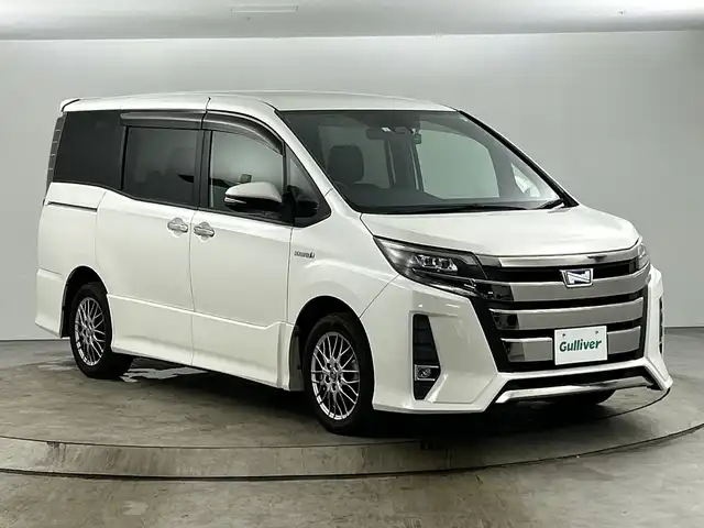 トヨタ ノア ハイブリッド Si ダブルバイビー 愛知県 2018(平30)年 5.2万km ホワイトパールクリスタルシャイン 禁煙車/純正9インチSDナビ/　（フルセグTV/CD/DVD/SD/Bluetooth）/バックカメラ/トヨタセーフティセンス/・プリクラッシュセーフティ/・レーンキープアシスト/・オートマチックハイビーム/・先行車発信お知らせ機能/クルーズコントロール/ETC/ドライブレコーダー/前席シートヒーター/両側パワースライドドア/純正16インチアルミホイール/LEDヘッドライト/フロントフォグランプ/横滑り防止機能/純正フロアマット/純正ドアバイザー/スマートキー/スペアキー有
