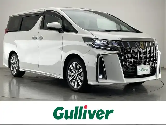 トヨタ アルファード S タイプゴールドⅡ 愛知県 2021(令3)年 1.8万km ホワイトパールクリスタルシャイン メーカーナビ　ＪＢＬ　Ｗムーンルーフ　パーキングアシスト　リアエンターテイメントシステム　デジタルインナーミラー　全方位カメラ　ＤＶＤデッキ　ＡＣ１００Ｖ　三眼ＬＥＤ　衝突軽減　追従クルコン　ＢＳＭ　セーフティセンス　パワーバックドア　前後ドラレコ　オットマン　ハーフレザー　電動パーキング