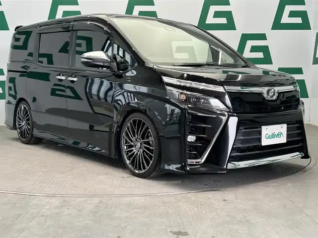 トヨタ ヴォクシー ZS 煌 鹿児島県 2018(平30)年 7.5万km ブラック ワンオーナー/社外ナビ（NX617）/バックカメラ/両側パワースライドドア/前後ドライブレコーダー/ETC/フルセグTV/アダプティブクルーズコントロール/レーンキープアシスト/社外マフラー/純正フロアマット/革調シートカバー/アイドリングストップ/ドアバイザー/社外19インチアルミホイール（RAY’ｓ）/LEDヘッドライト