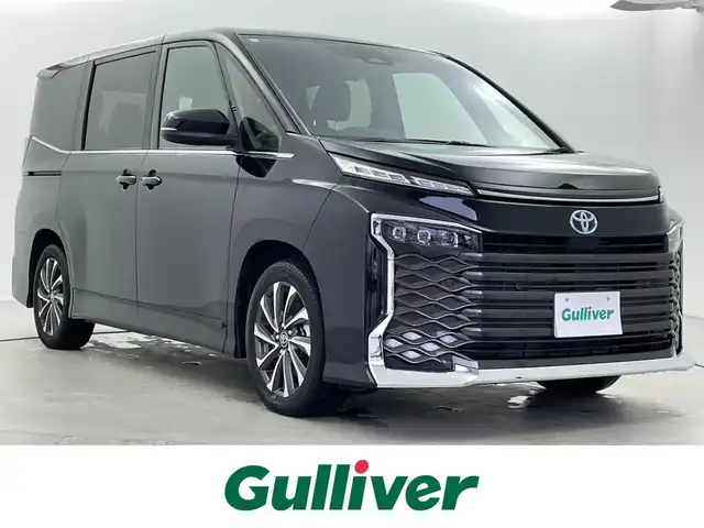 トヨタ ヴォクシー ハイブリッド S－Z 福井県 2024(令6)年 0.8万km アティチュードブラックマイカ 純正ディスプレイナビ/Bluetooth/USB/Miracast/AM/FM/バックカメラ/トヨタセーフティセンス/・プリクラッシュセーフティ/・レーントレーシングアシスト/・レーンディパーチャーアラート/・レーダークルーズコントロール/・アダプティブハイビームシステム／オートマチックハイビーム/・ロードサインアシスト：標識の見逃し防止をサポート/・ドライバー異常時対応システム/・プロアクティブドライビングアシスト/・発進遅れ告知機能/・緊急時操舵支援（アクティブ操舵機能付）/両側パワースライドドア/レーダークルーズコントロール/LEDオートライト/オートマチックハイビーム/ハーフレザーシート/シートヒーター/コーナーセンサー/スマートキー