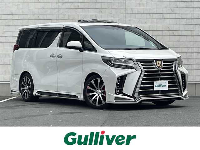トヨタ アルファード S タイプゴールド 愛知県 2020(令2)年 6.7万km ホワイトパールクリスタルシャイン ・ROJAM IRT GENIK フルエアロ/・ROJAMマフラー/・ROJAMキャリパーカバー/・TEIN車高調/・純正JBLサウンド付ディスプレイオーディオ（ナビ有り）/・フルセグTV/・CD/DVD再生/・ミュージックサーバー（SD録音）/・Bluetooth/USB接続/・全方位カメラ/・ETC2.0/・電動開閉フリップダウンモニター/・両側パワースライドドア/・社外製19インチアルミホイール/・サンルーフ/・純正フロアマット/・オットマン/・電動リアゲート/・LEDヘッドライト/・オートマチックハイビーム/・コーナーセンサー/・横滑り防止装置/・衝突軽減ブレーキ/・レーンキープアシスト/・電動パーキングブレーキ/・ブレーキホールド/・デジタルインナーミラー/・ドライブレコーダー（デジタルインナーミラー内蔵型）/・アダプティブクルーズコントロール/・ルーフカラーイルミネーション