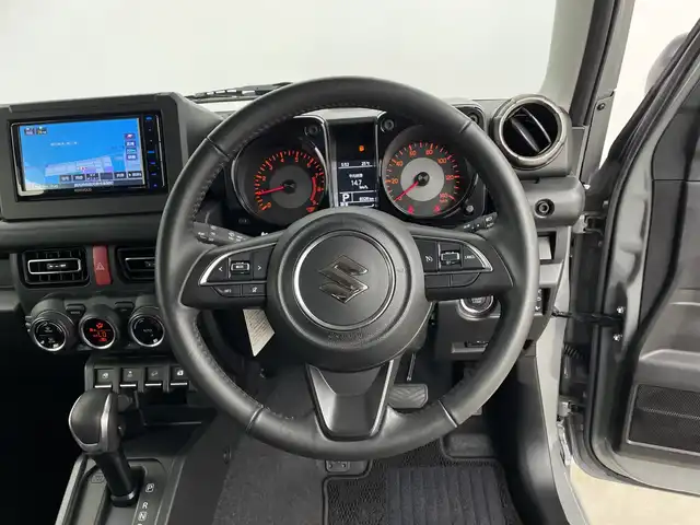 スズキ ジムニー XC 鹿児島県 2024(令6)年 0.9万km ミディアムグレー 純正SDナビ/（AM/FM/CD/DVD/Bluetooth）/バックカメラ/前後ドライブレコーダー/クルーズコントロール/ETC/シートヒーター/SUZUKIフロントグリル/レザー調シートカバー/背面タイヤ/オートライト/LEDヘッドライト/純正16インチAW/ドアバイザー
