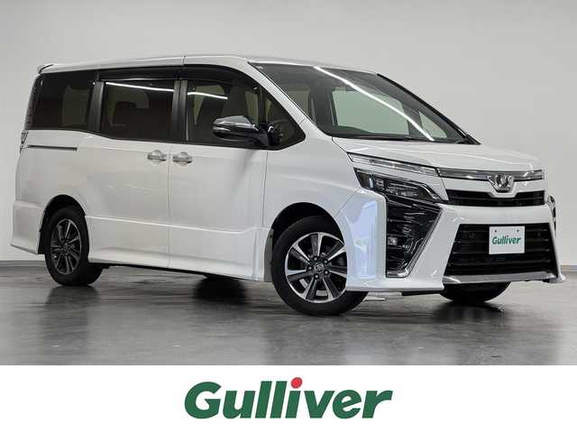 トヨタ ヴォクシー ZS 煌Ⅱ 三重県 2019(令1)年 6.3万km ホワイトパールクリスタルシャイン ガソリン/FF/MTモード付インパネCVT/純正 9インチナビ NSZT-Y68T/（AM/FM/CD/DVD/TV/SD/SDREC/Bluetooth）/純正 12.1インチ 後席フリップダウンモニター V12T-R68C/バックガイドモニター/両側パワースライドドア/ドライブレコーダー 前後/ビルトイン ETC/Toyota Safety Sense/・プリクラッシュセーフティ［PCS］/・レーンディパーチャーアラート［LDA］/・オートハイビーム［AHB］/・インテリジェントクリアランスソナー（パーキングサポートブレーキ［PKSB］（静止物））/装備/・クルーズコントロール/・左右独立オートエアコン/・後席独立オートエアコン/・オートライト/・LED ヘッドランプ＋フロントフォグランプ/・ステアリングスイッチ/・充電用USBジャック x2/・純正16inAW/・保/取/ナビ取/・スマートキーx2