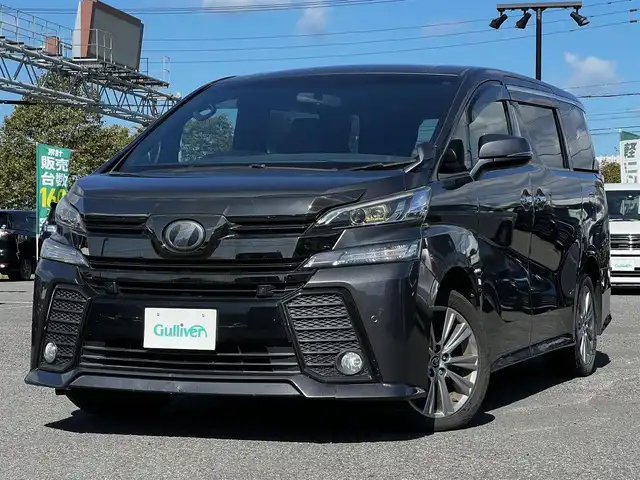 トヨタ ヴェルファイア 3.5ZA ゴールデンアイズ 道央・札幌 2016(平28)年 7.7万km グレーメタリック ４WD/純正SDナビ/AM/FM/BT/CD/DVD/フルセグ/純正フリップダウンモニター/衝突被害軽減ブレーキ/横滑り防止装置/レーダークルーズコントロール/クリアランスソナー/バックカメラ/ビルトインETC/ECOMODE/両側パワースライドドア/パワーバックドア/オットマン/ハーフレザーシート/革巻きウッドコンビステアリング/ステアリングリモコン/AC100V/電動パーキング/ブレーキホールド/MTモード付AT/プッシュスタート/スマートキー/LEDヘッドライト/オートライト/フォグランプ/電動格納ミラー/ウィンカーミラー/純正フロアマット/ドアバイザー