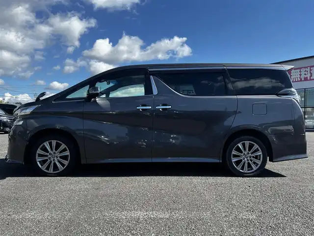 トヨタ ヴェルファイア 3.5ZA ゴールデンアイズ 道央・札幌 2016(平28)年 7.7万km グレーメタリック ４WD/純正SDナビ/AM/FM/BT/CD/DVD/フルセグ/純正フリップダウンモニター/衝突被害軽減ブレーキ/横滑り防止装置/レーダークルーズコントロール/クリアランスソナー/バックカメラ/ビルトインETC/ECOMODE/両側パワースライドドア/パワーバックドア/オットマン/ハーフレザーシート/革巻きウッドコンビステアリング/ステアリングリモコン/AC100V/電動パーキング/ブレーキホールド/MTモード付AT/プッシュスタート/スマートキー/LEDヘッドライト/オートライト/フォグランプ/電動格納ミラー/ウィンカーミラー/純正フロアマット/ドアバイザー