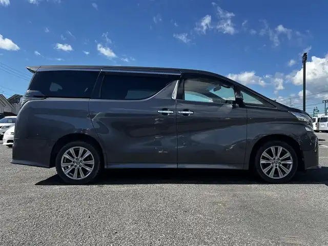 トヨタ ヴェルファイア 3.5ZA ゴールデンアイズ 道央・札幌 2016(平28)年 7.7万km グレーメタリック ４WD/純正SDナビ/AM/FM/BT/CD/DVD/フルセグ/純正フリップダウンモニター/衝突被害軽減ブレーキ/横滑り防止装置/レーダークルーズコントロール/クリアランスソナー/バックカメラ/ビルトインETC/ECOMODE/両側パワースライドドア/パワーバックドア/オットマン/ハーフレザーシート/革巻きウッドコンビステアリング/ステアリングリモコン/AC100V/電動パーキング/ブレーキホールド/MTモード付AT/プッシュスタート/スマートキー/LEDヘッドライト/オートライト/フォグランプ/電動格納ミラー/ウィンカーミラー/純正フロアマット/ドアバイザー