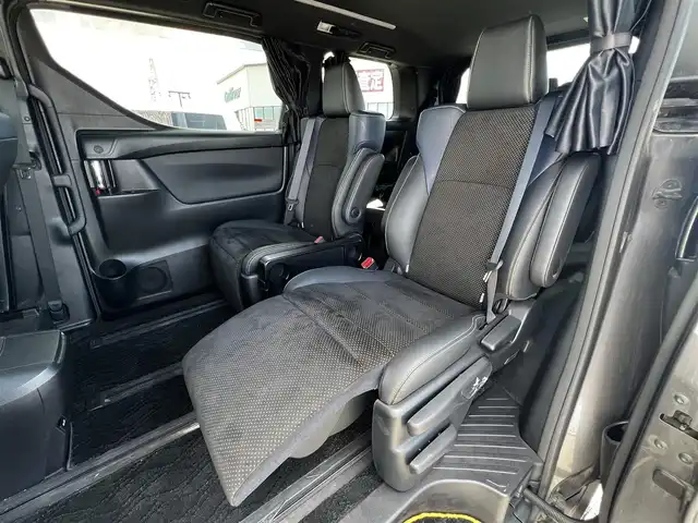 トヨタ ヴェルファイア 3.5ZA ゴールデンアイズ 道央・札幌 2016(平28)年 7.7万km グレーメタリック ４WD/純正SDナビ/AM/FM/BT/CD/DVD/フルセグ/純正フリップダウンモニター/衝突被害軽減ブレーキ/横滑り防止装置/レーダークルーズコントロール/クリアランスソナー/バックカメラ/ビルトインETC/ECOMODE/両側パワースライドドア/パワーバックドア/オットマン/ハーフレザーシート/革巻きウッドコンビステアリング/ステアリングリモコン/AC100V/電動パーキング/ブレーキホールド/MTモード付AT/プッシュスタート/スマートキー/LEDヘッドライト/オートライト/フォグランプ/電動格納ミラー/ウィンカーミラー/純正フロアマット/ドアバイザー