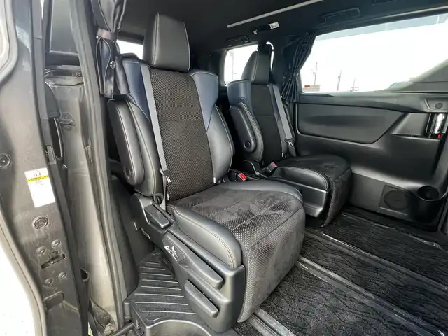 トヨタ ヴェルファイア 3.5ZA ゴールデンアイズ 道央・札幌 2016(平28)年 7.7万km グレーメタリック ４WD/純正SDナビ/AM/FM/BT/CD/DVD/フルセグ/純正フリップダウンモニター/衝突被害軽減ブレーキ/横滑り防止装置/レーダークルーズコントロール/クリアランスソナー/バックカメラ/ビルトインETC/ECOMODE/両側パワースライドドア/パワーバックドア/オットマン/ハーフレザーシート/革巻きウッドコンビステアリング/ステアリングリモコン/AC100V/電動パーキング/ブレーキホールド/MTモード付AT/プッシュスタート/スマートキー/LEDヘッドライト/オートライト/フォグランプ/電動格納ミラー/ウィンカーミラー/純正フロアマット/ドアバイザー