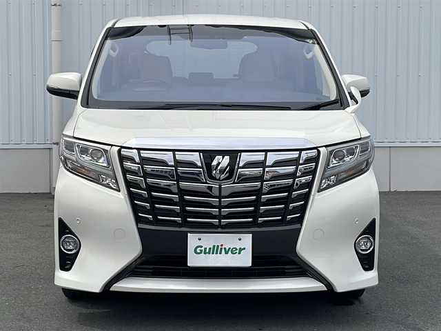 トヨタ アルファード G 三重県 2015(平27)年 5.7万km ラグジュアリーホワイトパールクリスタルシャインガラスフレーク プッシュスタート/電動格納ミラー/両側パワースライドドア/ビルトインETC/横滑り防止/レーダークルーズコントロール/パワーシート{D+N席）/オットマン/ステアリングスイッチ/革巻きステアリング/オートライト/前後ドライブレコーダー/後席フリップダウンモニター/電動パーキング/純正フロアマット/純正9型ナビ（AM/FM/CD/DVD/TV/BT）/フルセグTV/コーナーセンサー/パワーバックドア/スペアキー/リアサンシェード/LEDヘッドライト