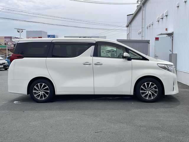 トヨタ アルファード G 三重県 2015(平27)年 5.7万km ラグジュアリーホワイトパールクリスタルシャインガラスフレーク プッシュスタート/電動格納ミラー/両側パワースライドドア/ビルトインETC/横滑り防止/レーダークルーズコントロール/パワーシート{D+N席）/オットマン/ステアリングスイッチ/革巻きステアリング/オートライト/前後ドライブレコーダー/後席フリップダウンモニター/電動パーキング/純正フロアマット/純正9型ナビ（AM/FM/CD/DVD/TV/BT）/フルセグTV/コーナーセンサー/パワーバックドア/スペアキー/リアサンシェード/LEDヘッドライト