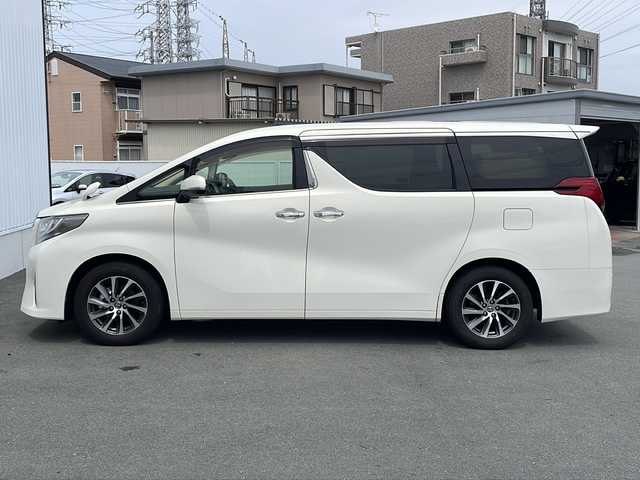 トヨタ アルファード G 三重県 2015(平27)年 5.7万km ラグジュアリーホワイトパールクリスタルシャインガラスフレーク プッシュスタート/電動格納ミラー/両側パワースライドドア/ビルトインETC/横滑り防止/レーダークルーズコントロール/パワーシート{D+N席）/オットマン/ステアリングスイッチ/革巻きステアリング/オートライト/前後ドライブレコーダー/後席フリップダウンモニター/電動パーキング/純正フロアマット/純正9型ナビ（AM/FM/CD/DVD/TV/BT）/フルセグTV/コーナーセンサー/パワーバックドア/スペアキー/リアサンシェード/LEDヘッドライト