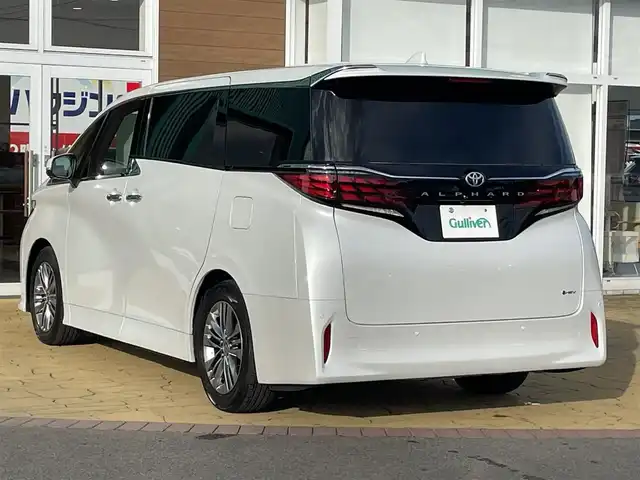 トヨタ アルファードハイブリット Z 宮崎県 2023(令5)年 2.3万km プラチナホワイトパールマイカ 左右独立ムーンルーフ/13.2インチフリップダウンモニター/セーフティセンス/・プリクラッシュセーフティ/・レーントレーシングアシスト/・レーンディパーチャーアラート/・全車速追従機能付レーダークルーズコントロール/・アダクティブハイビームシステム/・ロードサインアシスト/・ドライバー異常時対応システム/・プロアクティブドライビングアシスト/・発進遅れ告知機能/BSM（ブラインドスポットモニター）/14インチディスプレイオーディオ/ナビ／BT/USB/HDMI/フルセグTV／AppleCarPlay／Andorid audio/ETC2.0/パノラミックビューモニター/デジタルインナーミラー/おくだけ充電/パワーシート（運転席メモリー機能付）前席／2列目/パワーサンシェード　2列目／3列目/パワーバックドア/プッシュスタート／スマートキー/社外フロアマット