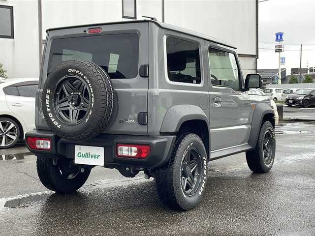 スズキ ジムニー シエラ JC 福井県 2023(令5)年 1万km ミディアムグレー 4WD/社外ディスプレイオーディオ/（Apple CarPlay）/プリクラッシュセーフティ/レーンキープアシスト/クルーズコントロール/純正16インチアルミホイール/背面タイヤ/LEDヘッドライト/フォグランプ/シートヒーター /アイドリングストップ/電動格納ミラー/オートライト/プッシュスタート/スマートキー/保証書/取扱説明書