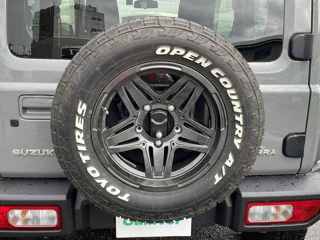 スズキ ジムニー シエラ JC 福井県 2023(令5)年 1万km ミディアムグレー 4WD/社外ディスプレイオーディオ/（Apple CarPlay）/プリクラッシュセーフティ/レーンキープアシスト/クルーズコントロール/純正16インチアルミホイール/背面タイヤ/LEDヘッドライト/フォグランプ/シートヒーター /アイドリングストップ/電動格納ミラー/オートライト/プッシュスタート/スマートキー/保証書/取扱説明書