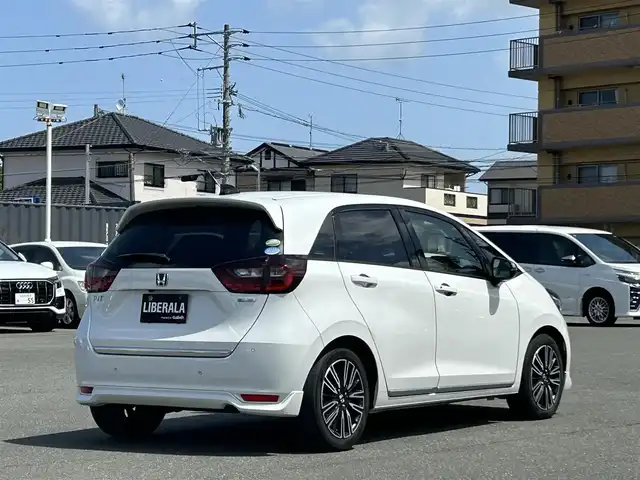 ホンダ フィット e:HEVリュクス 福岡県 2020(令2)年 4.8万km プラチナホワイトパール 社外ナビ(MDV-M906HD)/CD/DVD/SD/BT/フルセグ/ETC/バックカメラ/置くだけ充電/オートホールド/ホンダセンシング/レーンキープアシスト/革巻きステアリング/ステアリングスイッチ/ハーフレザーシート/シートヒーターD-N/LEDヘッドライト/オートライト/オートハイビーム/フォグライト前/コーナーセンサー前後/純正フロアマット/純正16AW