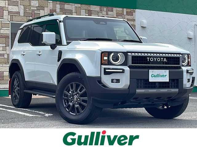 トヨタ ランドクルーザー ２５０ VX 徳島県 2024(令6)年 0.4万km プラチナホワイトパールマイカ サンルーフ/ヘッドランプ（丸目）/12.3インチ純正ディスプレイオーディオナビ /・フルセグTV /・Bluetooth/・Miracast/・USB/HDMI/パノラミックビューモニター/パワーシート（D+N席）/シートヒーター/エアシート（D+N席）/モデリスタ/・シグネチャーイルミブレード/・フェンダーガーニッシュ/・バックドアガーニッシュ/サイドステップ/マッドフラップ（赤）/ルーフレール/BSM/レーダークルーズコントロール/レーンキープアシスト/前後コーナーセンサー/LEDヘッドライト/オートライト/オートマチックハイビーム/フロントフォグランプ/ウィンカーミラー/Wサイドエアバッグ/カーテンエアバッグ/ナノイー