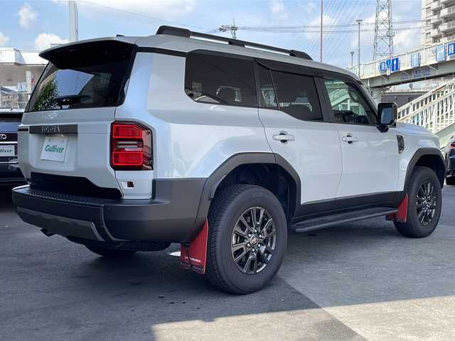 トヨタ ランドクルーザー ２５０ VX 徳島県 2024(令6)年 0.4万km プラチナホワイトパールマイカ サンルーフ/ヘッドランプ（丸目）/12.3インチ純正ディスプレイオーディオナビ /・フルセグTV /・Bluetooth/・Miracast/・USB/HDMI/パノラミックビューモニター/パワーシート（D+N席）/シートヒーター/エアシート（D+N席）/モデリスタ/・シグネチャーイルミブレード/・フェンダーガーニッシュ/・バックドアガーニッシュ/サイドステップ/マッドフラップ（赤）/ルーフレール/BSM/レーダークルーズコントロール/レーンキープアシスト/前後コーナーセンサー/LEDヘッドライト/オートライト/オートマチックハイビーム/フロントフォグランプ/ウィンカーミラー/Wサイドエアバッグ/カーテンエアバッグ/ナノイー