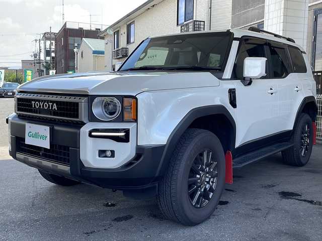 トヨタ ランドクルーザー ２５０ VX 徳島県 2024(令6)年 0.4万km プラチナホワイトパールマイカ サンルーフ/ヘッドランプ（丸目）/12.3インチ純正ディスプレイオーディオナビ /・フルセグTV /・Bluetooth/・Miracast/・USB/HDMI/パノラミックビューモニター/パワーシート（D+N席）/シートヒーター/エアシート（D+N席）/モデリスタ/・シグネチャーイルミブレード/・フェンダーガーニッシュ/・バックドアガーニッシュ/サイドステップ/マッドフラップ（赤）/ルーフレール/BSM/レーダークルーズコントロール/レーンキープアシスト/前後コーナーセンサー/LEDヘッドライト/オートライト/オートマチックハイビーム/フロントフォグランプ/ウィンカーミラー/Wサイドエアバッグ/カーテンエアバッグ/ナノイー