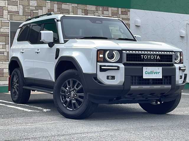 トヨタ ランドクルーザー ２５０ VX 徳島県 2024(令6)年 0.4万km プラチナホワイトパールマイカ サンルーフ/ヘッドランプ（丸目）/12.3インチ純正ディスプレイオーディオナビ /・フルセグTV /・Bluetooth/・Miracast/・USB/HDMI/パノラミックビューモニター/パワーシート（D+N席）/シートヒーター/エアシート（D+N席）/モデリスタ/・シグネチャーイルミブレード/・フェンダーガーニッシュ/・バックドアガーニッシュ/サイドステップ/マッドフラップ（赤）/ルーフレール/BSM/レーダークルーズコントロール/レーンキープアシスト/前後コーナーセンサー/LEDヘッドライト/オートライト/オートマチックハイビーム/フロントフォグランプ/ウィンカーミラー/Wサイドエアバッグ/カーテンエアバッグ/ナノイー