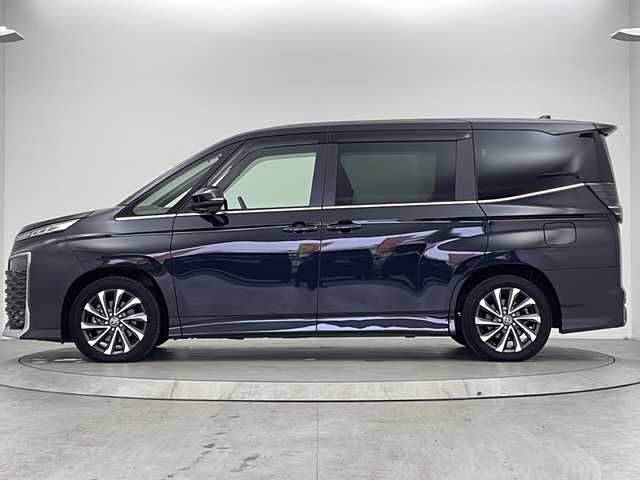 トヨタ ヴォクシー S－Z 大阪府 2022(令4)年 2.5万km グリッターブラックガラスフレーク 純正10.5インチディスプレイオーディオ/【ナビ/BT/フルセグTV/USB/DVD/HDMI]/バックカメラ/ETC2.0/ドライブレコーダー前後　TZ-DR210/快適利便パッケージ/・オットマン/・パワーバックドア/・ハンズフリーデュアルパワースライドドア/・ナイノーX/・ステアリングヒーター/・二列目シートヒーター/両側パワースライドドア/衝突被害軽減システム/ブラインドスポットモニター/クルーズコントロール追従/コーナーセンサー前後/オートライト/サンシェード/ハーフレザーシート/純正17インチAW/ワンオーナ/スペアキー