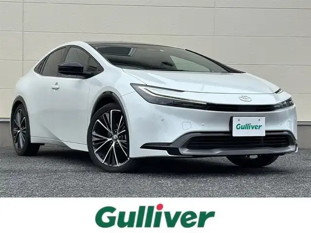 トヨタ プリウス Z 茨城県 2023(令5)年 6.3万km プラチナホワイトパールマイカ 12.3型ディスプレイオーディオ/　(AM/FM/USB/Bluetooth/フルセグ)/パノラミックビューモニター/ブラインドスポットモニター/パノラマムーンルーフ/セーフティセンス（予防安全パッケージ）/　・プリクラッシュセーフティ/　・緊急時操舵支援/　・フロントクロストラフィックアシスト/　・レーンディパーチャーアラート/　・レーダークルーズコントロール/　・オートマチックハイビーム/　・ロードサインアシスト/　・ドライバー異常時対応システム/　・プロアクティブドライビングアシスト/　・発進遅れ告知機能/ドライブレコーダー/トヨタチームメイト（アドバンストパーク）/パーキングサポートブレーキ/（前後方静止物/後方接近車両/後方歩行者/周囲静止物）/ETC2.0/LEDヘッドライト/ワイヤレス充電器/ステアリングヒーター/ハーフレザーシート/シートヒーター/エアシート/パワーシート/デジタルインナーミラー/純正アルミホイール/前後コーナーセンサー/レーンキープアシスト/エアバック/オートライト/スマートキー/保証書